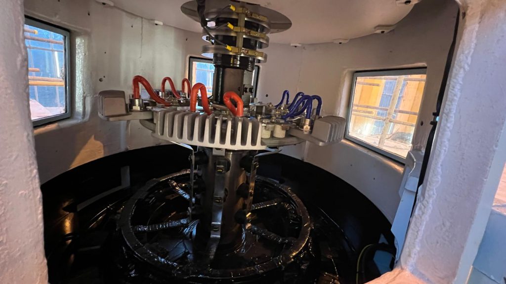 The inside of an excitation control unit, with coiled wires encircling a mechanical column