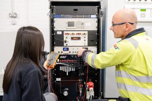 Two engineers examine electrical test equipment